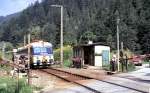 Bahn�berg�nge Der Zug, ein 4030 225-0 ist durch und sofort wird die Schranke durch kr�ftiges Handkurbeln wieder ge�ffnet beim Bahn�bergang zwischen Hieflau und Eisenerz, am 20.08.1987.