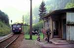 Bahn�berg�nge Der 5081 563 f�hrt an einem beschaulichen Dienstgeb�ude beim Bahn�bergang Hieflau - Eisenerz am 21.08.1987 vorbei. Im Vordergrund lohnt es sich die Handkurbel f�r die Schranke zu betrachten, ebenso wie die gepflegen Blumenk�sten oder das Moped.